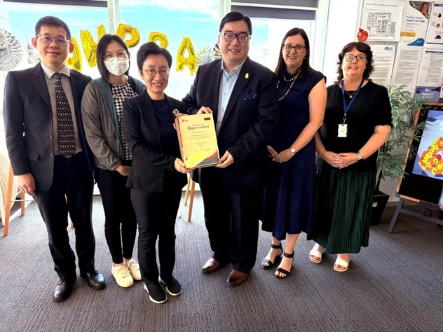 A group of people with one holding a certificate
